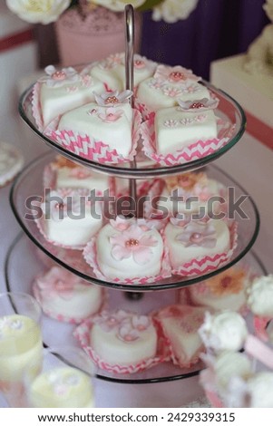 Pyramid with different sweets for parties, birthday. Wedding festive desserts white and pink color with flowers
