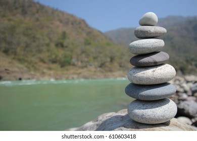 Pyramid Of Flat Stones Against The Background Of The River And Mountains. Meditative Reiki Concept.