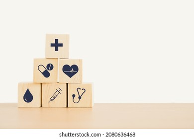 pyramid of health and medical icon on wooden cubes on desk with copy space for health insurance, wellness, wellbeing concept