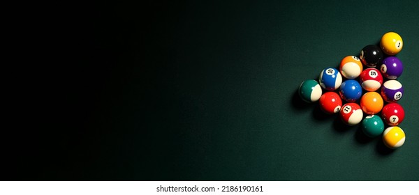 Pyramid made of billiard balls on dark background with space for text