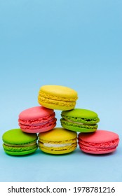 pyramid of multicolored macaron cakes on a blue paper background