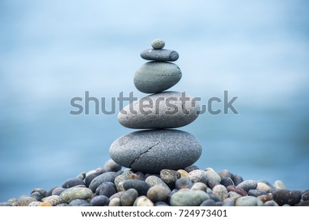 Pyramid of pebbles on the beach.Waves in background