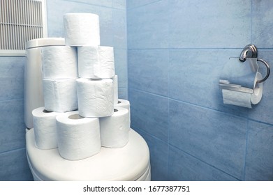 A Pyramid Of Rolls Of Toilet Paper Is Standing On The Toilet. Heap, Mountain, A Lot