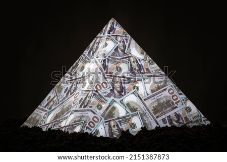 a pyramid scheme on a black background. The concept of financial fraud. The dollar as a global financial pyramid.