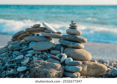 Pyramid of sea pebbles on a turquoise sea background - Powered by Shutterstock