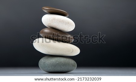 pyramid of stacked stones on a dark background. stabilization and balance in life