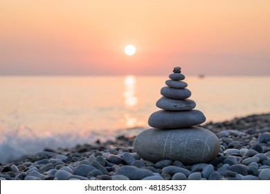 Pyramid Of Stones For Meditation Lying On Sea Coast At Sunset