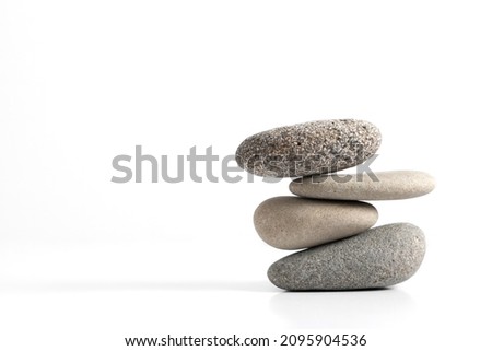 Pyramid of various sea pebbles, pyramid of balanced stones Isolated on white background. Concept harmony, life balance and meditation.