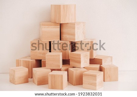 Pyramid of wooden blocks from natural wood on a white background. Copy, empty space for text.
