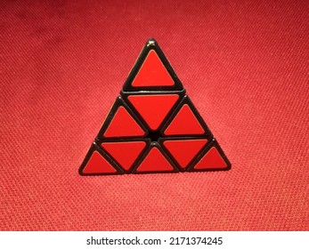 Pyraminx Cube On Red Background.