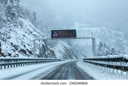 Pyrenees, Spain - Circa December 2018: Heavy Snow Storm On The Road And Alert Sign. Pyrenees Region, North Of Spain. Snow Chains Alert. Tunnel Warning