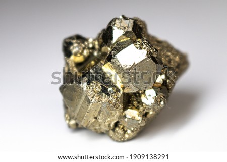 Pyrite cube up close on a neutral white background.
