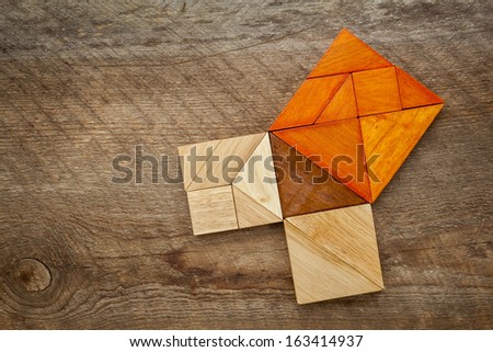 Pythagorean theorem illustrated with wooden pieces of tangram, a classic Chinese puzzle, against barn wood background