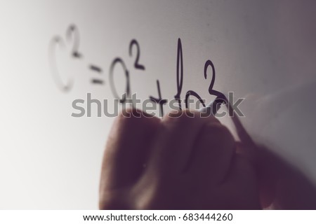 Pythagorean theorem, also known as Pythagoras's theorem, math class in the school with teacher writing mathematical formula on white board, selective focus
