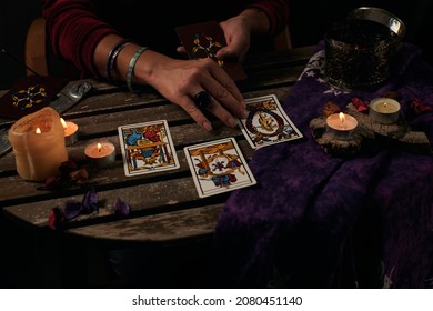 Pythoness Reads Tarot Cards On A Table With Candles