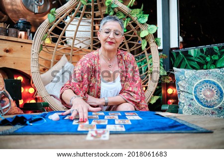 a pythoness woman using tarot cards to predict the future