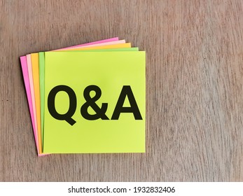 Q and A concept. Selective focus sticky note with phrase Q and A isolated on wooden background. 