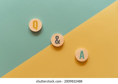 Q and A concept. Wooden cube with Q and A text on yellow and green background.  Business concept
