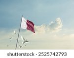 Qatar flag waving with flying doves in beautiful sky. Qatar flag for Republic Day and Independence Day.