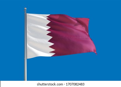 Qatar national flag waving in the wind on a deep blue sky. High quality fabric. International relations concept.