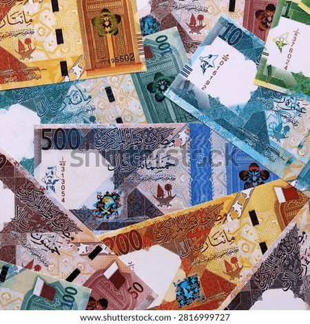 Qatari riyal money bills pile on table. Qatar banknotes of QAR currency close up. Concept of business, economy and investment in Qatar.