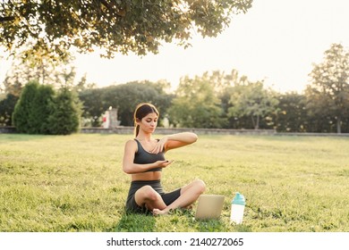 Qigong Chinese Meditation Online With Laptop In Green Park. Sport Training Outdoor. Fit Asian Girl Is Meditating Outside