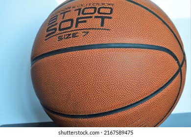 Qingdao, Shandong, China - June 12 2022: Round Brown Orange Faux Leather Rubber Basketball With Black Lines Closeup On The Bumpy Texture Perfect For Sports Games Marketing Advertising And Retail.