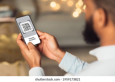 QR code on mobile phone screen, closeup. Unrecognizable african american man holding modern smartphone with bar code, paying for goods and services with payment system, creative image
