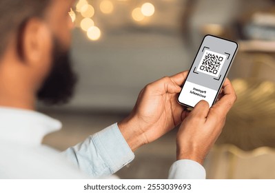 QR code on mobile phone screen, closeup. Unrecognizable african american man holding modern smartphone with bar code, paying for goods and services with payment system, creative image - Powered by Shutterstock - Get 15% off with code: PIKWIZARD15