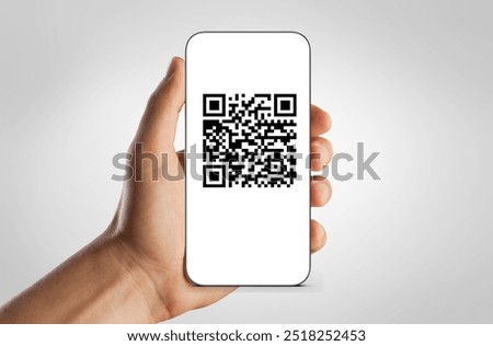 QR code on screen of mobile phone in human hands