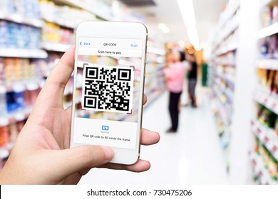Qr code payment , online shopping , cashless technology concept. Retail shop accepted digital pay without money. Hands using mobile phone application to scan code in department store background.