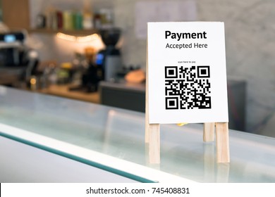 Qr code payment , online shopping , cashless society technology concept. Coffee shop accepted digital pay without money , wood stand tag on table.