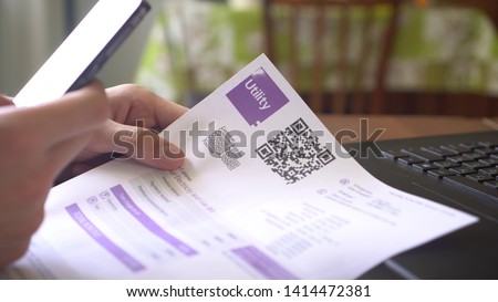 QR Code Payment. Utility Billing Online. Payment of utilities using QR code and mobile device. A man scanning the QR code with app and paying utility bills using his smartphone