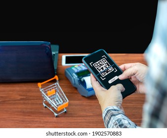 QR code scanning payment and verification. Businessman holding mobile smart phone  scanning  payment, buy and sell products 