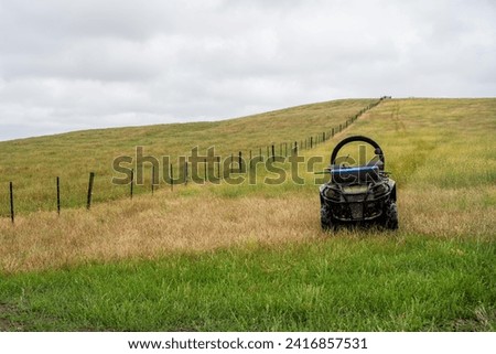 quad bike with a crush protection rollbar installed for safety in australia. australian motorbike in a field on a farm