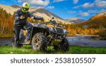 quad bike. A man on an ATV ride through the mountains. The ATV overcomes hilly terrain. Yellow ATV in the mountains. The concept is extreme sports. A man overcomes a mountainous area