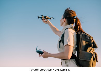 Quadcopter launch. Young woman tourist holds a drone in his hand lifting it up. Selective focus.