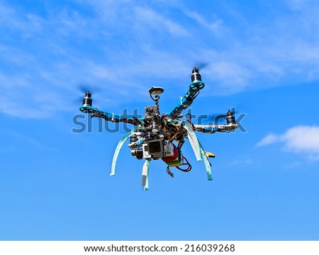 Quadrocopter drone with digital camera flying in the sky