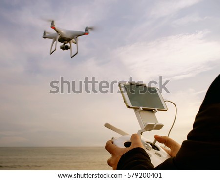 quadrocopter drone with remote control unit at man hands