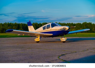 Quadruple Aircraft Parked At A Private Airfield. Rear View Of A Plane With A Propeller On A Sunset Background.