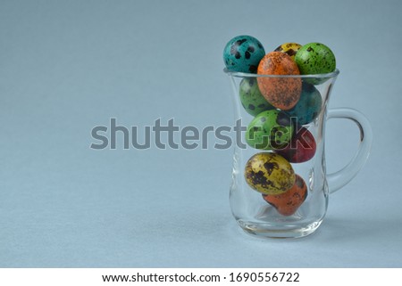 The quail painted eggs in a glass mug on a blue background. Easter card Foto stock © 
