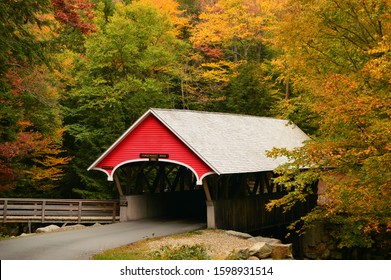 A quaint covered bridge is surrounded by brilliant autumn foliage - Powered by Shutterstock