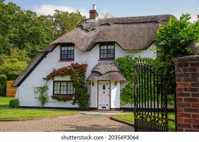 Quaint English cottage with traditional thatched roof. White country cottage in Hampshire England 