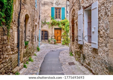 A quaint narrow lane running through the medieval area of Vaison la Romaine, a village in the Vaucluse region of Provence, France.