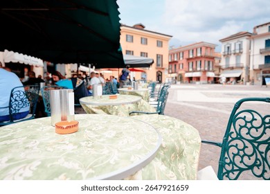Quaint outdoor cafe setting in a charming European square featuring colorful buildings and relaxing ambiance.