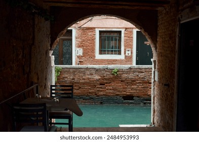 Quaint Venetian Canal View Through a Historic Archway - Powered by Shutterstock