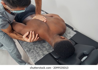 Qualified Caucasian osteopathic physician treating shoulder subluxation