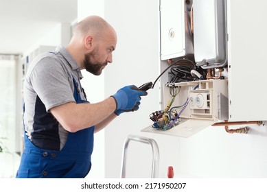 Qualified Engineer Checking Flue Gas Emissions On A Domestic Gas Boiler Using A Flue Gas Analyzer