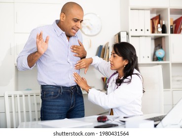 Qualified Female Doctor Palpating Abdomen Of Male Patient Complaining Of Pain In Medical Office