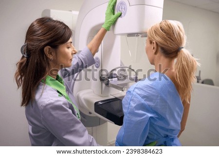 Qualified mammographer preparing woman for screening mammogram
